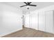 Simple bedroom with wood-look floors and ceiling fan at 1603 Woodlyn Dr, Leesburg, FL 34748
