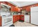 Efficient kitchen featuring wood cabinets and white appliances at 1815 Larkin Ave, Orlando, FL 32812