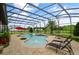 Inviting pool area with covered patio, lounge chairs, and lush landscaping at 2393 Appy Ln, Apopka, FL 32712