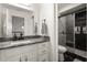 Modern bathroom with a walk-in shower, dark tile, and white vanity at 2393 Appy Ln, Apopka, FL 32712