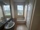 Bathroom with granite vanity, bathtub, and large window at 7706 Excitement Dr, Reunion, FL 34747