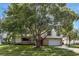 Two-story house with brick and white siding, attached garage, and mature tree in the front yard at 888 Chokecherry Dr, Winter Springs, FL 32708