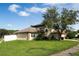 Two story house with solar panels, brick accents, and a large tree in the front yard at 12986 Maribou Cir, Orlando, FL 32828