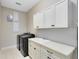 Bright laundry room with washer, dryer, and cabinets at 13168 Lower Harden Ave, Orlando, FL 32827