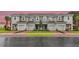 Three-unit townhome building with attached garages and landscaping at 195 River Front Way, Edgewater, FL 32141