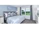 Main bedroom with a blue accent wall, a king bed, and a large window at 195 River Front Way, Edgewater, FL 32141