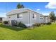 Side view of gray manufactured home with landscaping and AC unit at 6 Orangewood Dr, Fruitland Park, FL 34731