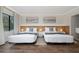 Spacious bedroom with two beds, hardwood floors and stylish wall decor at 6165 Carrier Dr # 1210, Orlando, FL 32819