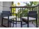 Relaxing balcony with wicker chairs and glass table, overlooking lush greenery at 6165 Carrier Dr # 1210, Orlando, FL 32819