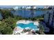 Community pool with lake view and nearby seating at 6165 Carrier Dr # 1210, Orlando, FL 32819