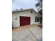 Attached garage with a red door and star accent at 821 Dundee Cir, Leesburg, FL 34788