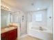 Bathroom with soaking tub, shower, and wood vanity at 223 Abbotsbury Dr, Kissimmee, FL 34758