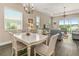 Bright dining room with white table and chairs, overlooking a lake at 8632 Bridgeport Bay Cir, Mount Dora, FL 32757