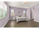 Purple bedroom with queen bed and hardwood floors at 8632 Bridgeport Bay Cir, Mount Dora, FL 32757