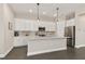 Modern kitchen with white cabinets, granite countertops, and stainless steel appliances at 8632 Bridgeport Bay Cir, Mount Dora, FL 32757