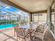 Covered patio with table and chairs, overlooking a refreshing pool at 8844 Corcovado Dr, Kissimmee, FL 34747