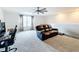 Spacious bonus room with leather couch, workspace, and ceiling fan at 5616 Arborvista Dr, St Cloud, FL 34771
