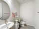 Clean bathroom with a pedestal sink, toilet, and shelving unit at 5616 Arborvista Dr, St Cloud, FL 34771