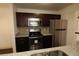Modern kitchen with granite countertops and dark cabinets at 4400 Thornbriar Ln # A202, Orlando, FL 32822