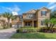Two-story house with a two car garage, lush landscaping, and solar panels at 16328 Wind View Ln, Winter Garden, FL 34787