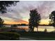 Scenic sunset view over a lake with a wooden dock at 16328 Wind View Ln, Winter Garden, FL 34787