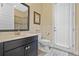 Bathroom with dark vanity, toilet, and door to outside at 16328 Wind View Ln, Winter Garden, FL 34787