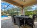 Covered patio with table and chairs overlooking the pool at 16328 Wind View Ln, Winter Garden, FL 34787