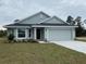 Single-story home with gray siding and two car garage at 4306 Sagefield Dr, Harmony, FL 34773