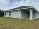 Exterior view of house with light gray siding and covered patio at 4306 Sagefield Dr, Harmony, FL 34773