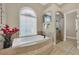 Bathroom with a soaking tub, a separate shower, and a large window at 364 Muirfield Loop, Reunion, FL 34747