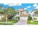 Two-story house with a three-car garage, light beige color, and a tile roof at 364 Muirfield Loop, Reunion, FL 34747