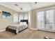 Bedroom with a king-size bed, arched windows, and access to balcony at 364 Muirfield Loop, Reunion, FL 34747