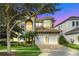Grand two story house with a three-car garage and manicured landscaping at 364 Muirfield Loop, Reunion, FL 34747