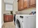 Bright laundry room with washer, dryer, sink, and ample cabinetry at 364 Muirfield Loop, Reunion, FL 34747