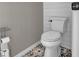 Clean bathroom with white toilet and patterned tile floor at 1409 Sutton Island Dr, Deland, FL 32724
