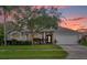 House exterior at sunset, showcasing a two-car garage and landscaping at 1409 Sutton Island Dr, Deland, FL 32724
