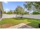 Spacious backyard with grassy lawn, fire pit, and white vinyl fence at 1409 Sutton Island Dr, Deland, FL 32724