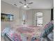 Main bedroom with large TV, en-suite bathroom access, and patterned bedding at 1409 Sutton Island Dr, Deland, FL 32724