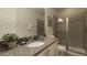 Bathroom with granite countertop, single sink, and glass shower at 7554 Marker Ave, Kissimmee, FL 34747