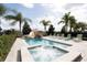 Relaxing pool and spa with surrounding lounge chairs and palm trees at 7554 Marker Ave, Kissimmee, FL 34747