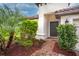 Front entry with brick walkway, lush landscaping, and dark brown door at 3951 Carrick Bend Dr, Kissimmee, FL 34746