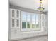 Built-in white cabinets with glass doors and drawers under a large window at 3951 Carrick Bend Dr, Kissimmee, FL 34746