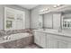 Elegant bathroom with double vanity, soaking tub, and large mirror at 3951 Carrick Bend Dr, Kissimmee, FL 34746