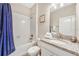 Bathroom with tub shower combo, granite countertop, and white cabinets at 4782 Kings Castle Cir, Kissimmee, FL 34746