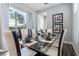 Dining room with glass table, chairs, and view of backyard from sliding glass door at 1407 Fairview Cir, Reunion, FL 34747