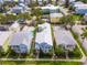 Aerial view of a house with a metal roof and pool in a residential neighborhood at 1407 Fairview Cir, Reunion, FL 34747
