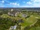 Aerial view of a golf course community with houses and a lake at 1407 Fairview Cir, Reunion, FL 34747