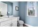 Clean bathroom with white vanity, toilet, and light blue walls at 1407 Fairview Cir, Reunion, FL 34747