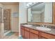 Double vanity bathroom with granite countertops and a large mirror at 909 Charo Pkwy # 1021, Davenport, FL 33897