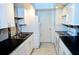 Bright galley kitchen with white cabinets, black countertops, and stainless steel appliances at 2649 Crown Ct # 2649, Kissimmee, FL 34741